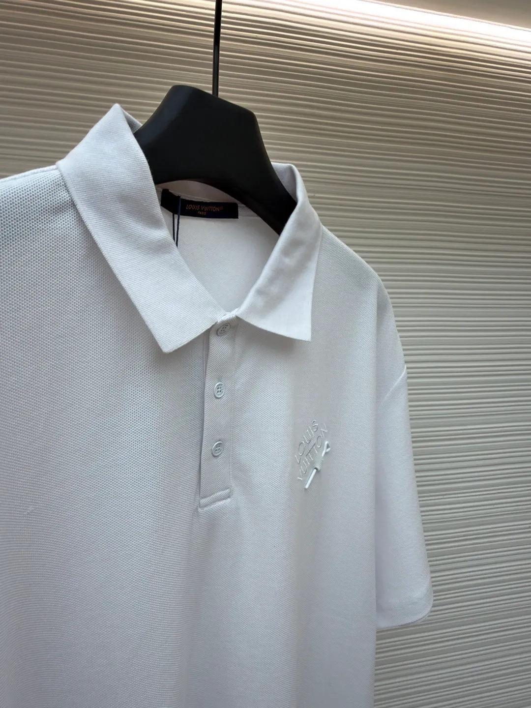 LOUIS VUITTON pin embroidered polo shirt ●Original version: Purchased and developed for 6500 ●Item number: 1681204-A35 ●Fabric: pique cotton fabric ●Technology: embroidery production ●Color: white ●Version: fitted version ●Weight: about 305 grams ●Size: XS-S-M-L ●Description: The fabric is made of customized 6-corner piqué cotton, with unique shape and texture, which is breathable and comfortable, not easy to deform and has greatly increased durability; the flat-knit thread dyeing for the neckline ensures that the color of the neckline perfectly matches the overall tone of the clothes. The flat-knit thread production process makes the neckline highly elastic and fits the neck without feeling constrained when worn; a keyhole is specially made under the embroidery, and custom-made pin accessories are strung together as decorative highlights to add a sense of fashion and uniqueness to the clothes. The overall wiring is straight and delicate, the fabric is comfortable and soft, and the color is consistent without color difference. It can be matched with the same style to create a fashionable look and control various occasions. Customized accessories, complete with three standards, same style for men and women!